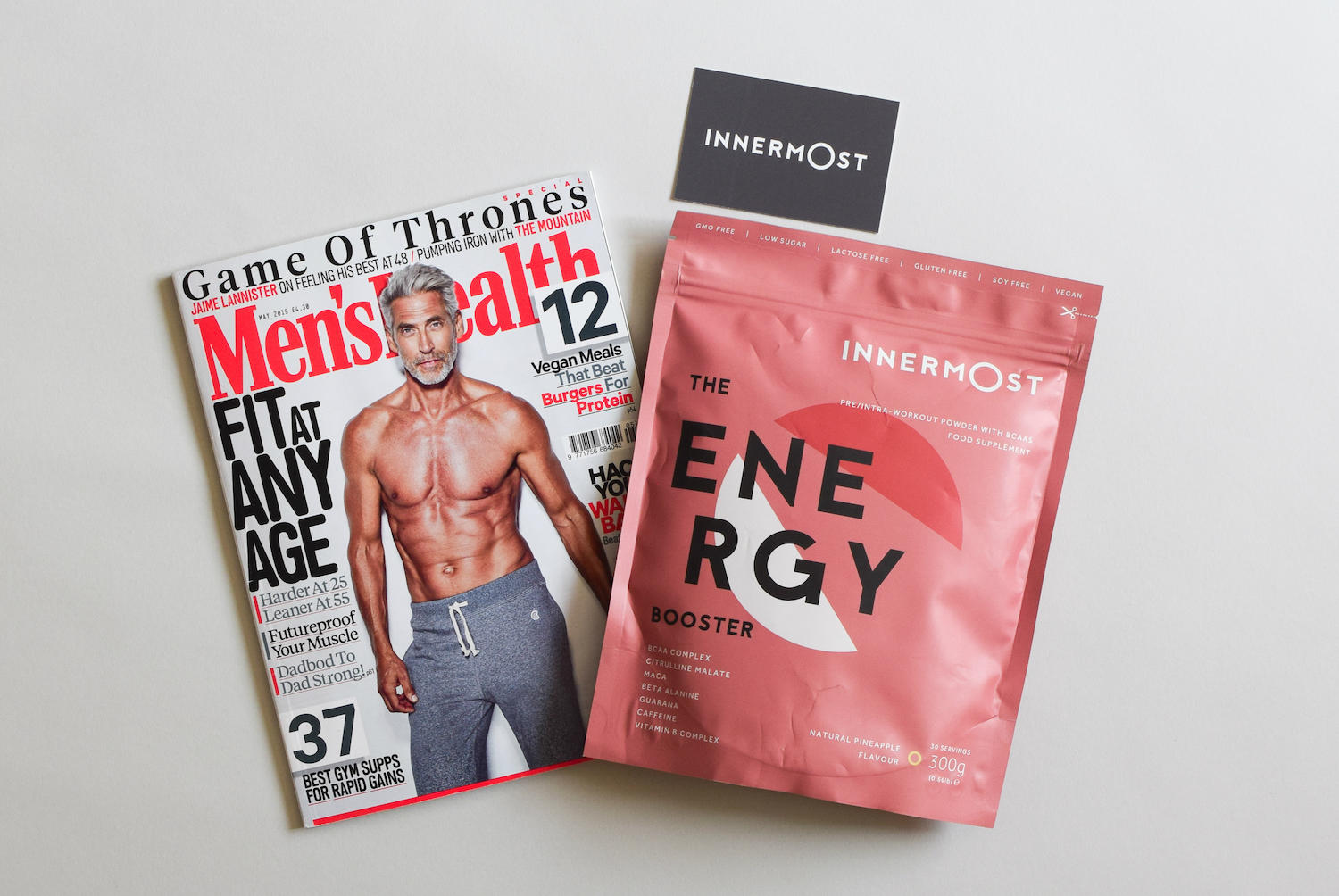 A photo showing a Men's Health magazine, an Innermost business card and an Innermost protein product.